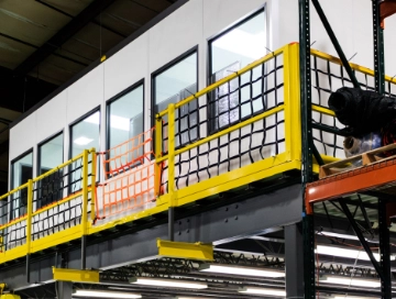 Industrial mezzanine safety netting installed in a warehouse to protect workers and prevent falls from elevated platforms